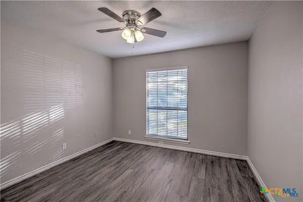 an empty room with wooden floor and window