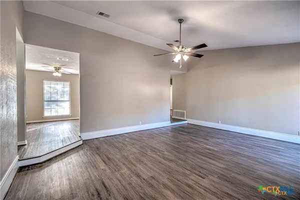 wooden floor in an empty room with a window