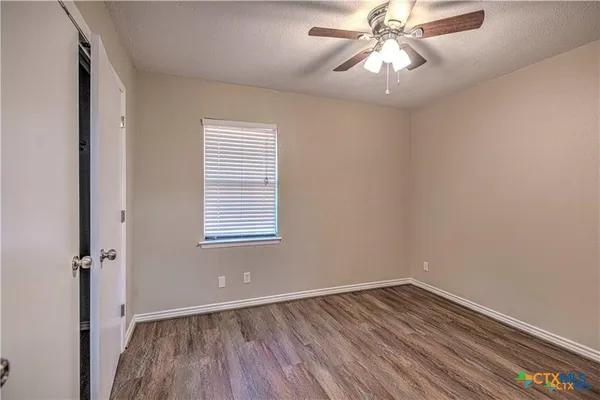 an empty room with a window and wooden floor