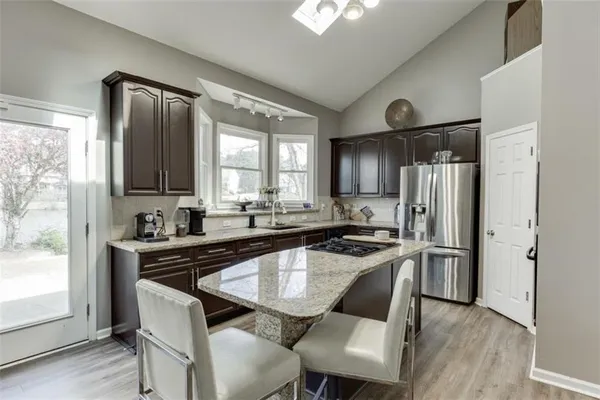 a kitchen with stainless steel appliances granite countertop a sink stove and cabinets