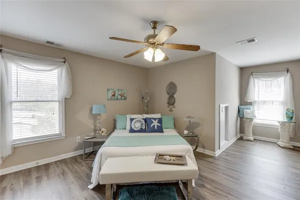 a bedroom with a large bed and a flat tv screen on dresser