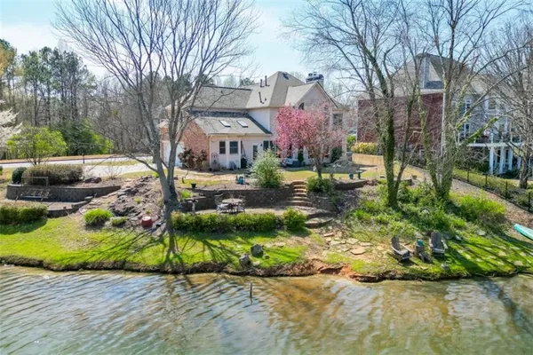 an aerial view of residential house with outdoor space and trees all around