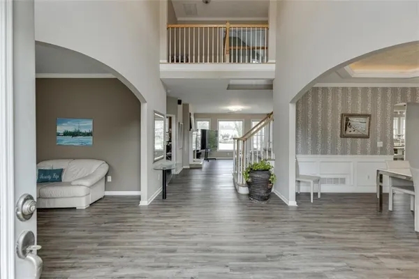 a living room with furniture floor to ceiling window and wooden floor