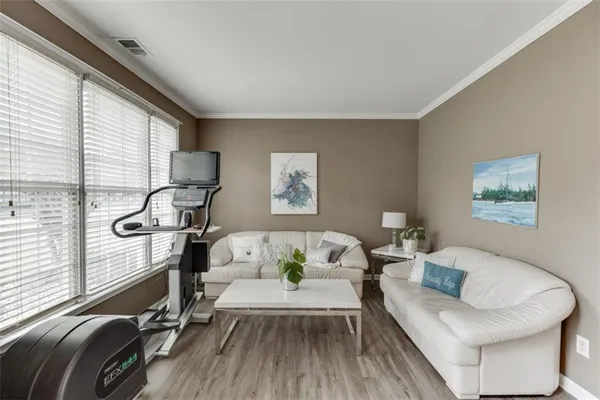 a dining room with furniture potted plants and wooden floor
