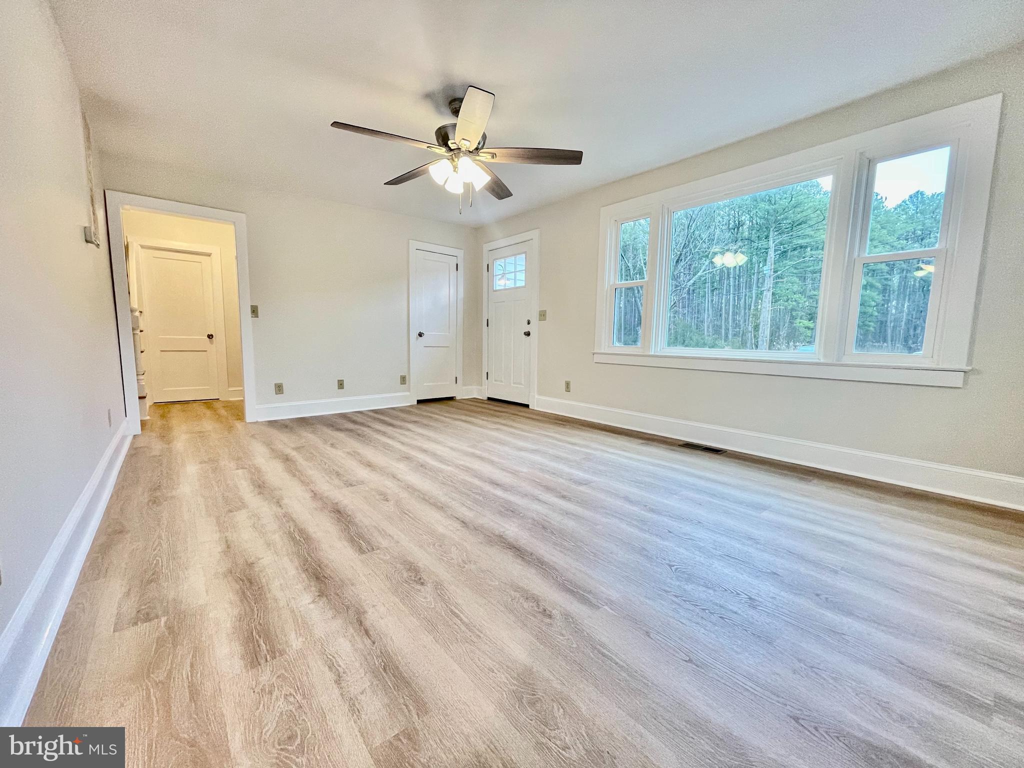 26540 Deal Island Road Princess Anne, MD 21853 - Photo 12 of 76 a view of an empty room with wooden floor and a window