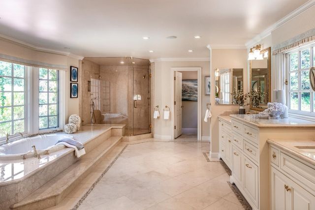 a large spacious bathroom with a double vanity sink large mirror and a bathtub