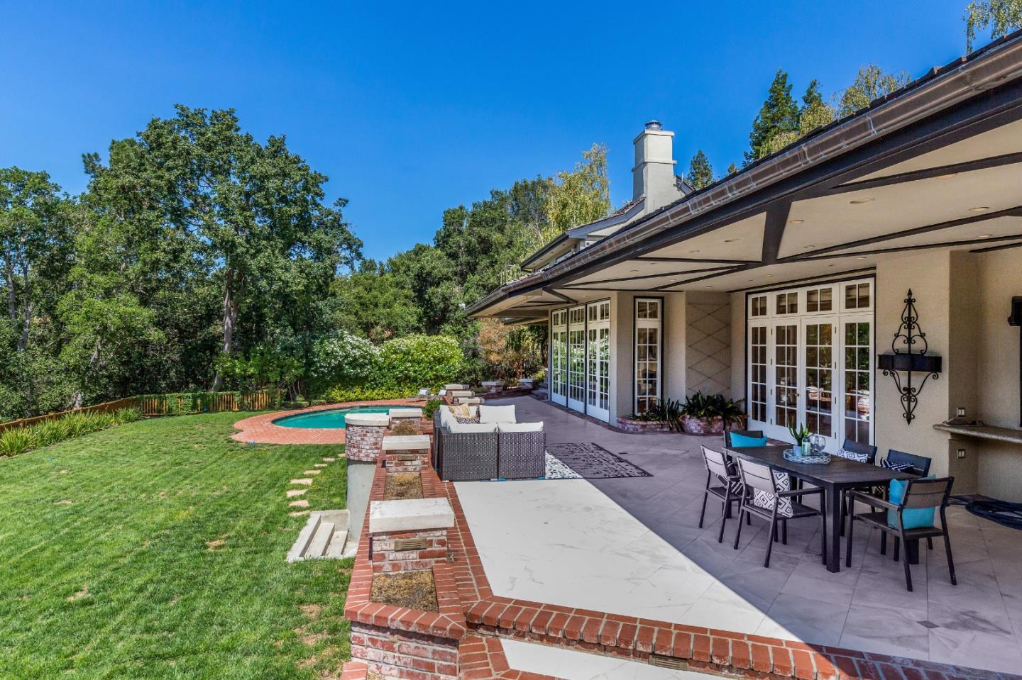 165 Farm Road Woodside, CA 94062 - Photo 22 of 29 a view of a patio with table and chairs potted plants and palm tree