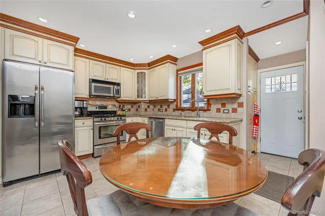 a kitchen with stainless steel appliances granite countertop a sink a stove and a refrigerator