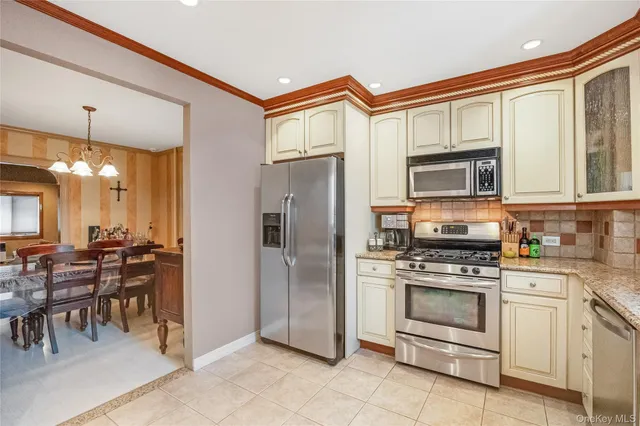 a kitchen with stainless steel appliances granite countertop a stove a refrigerator and a microwave