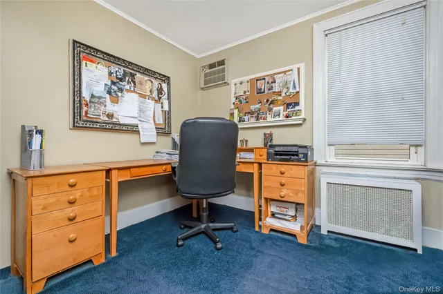 a view of a workspace with furniture and a window