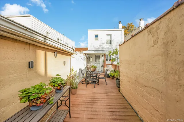 a view of a patio with wooden floor and a potted plant