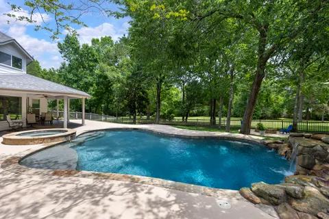 a view of a swimming pool with lawn chairs under an umbrella