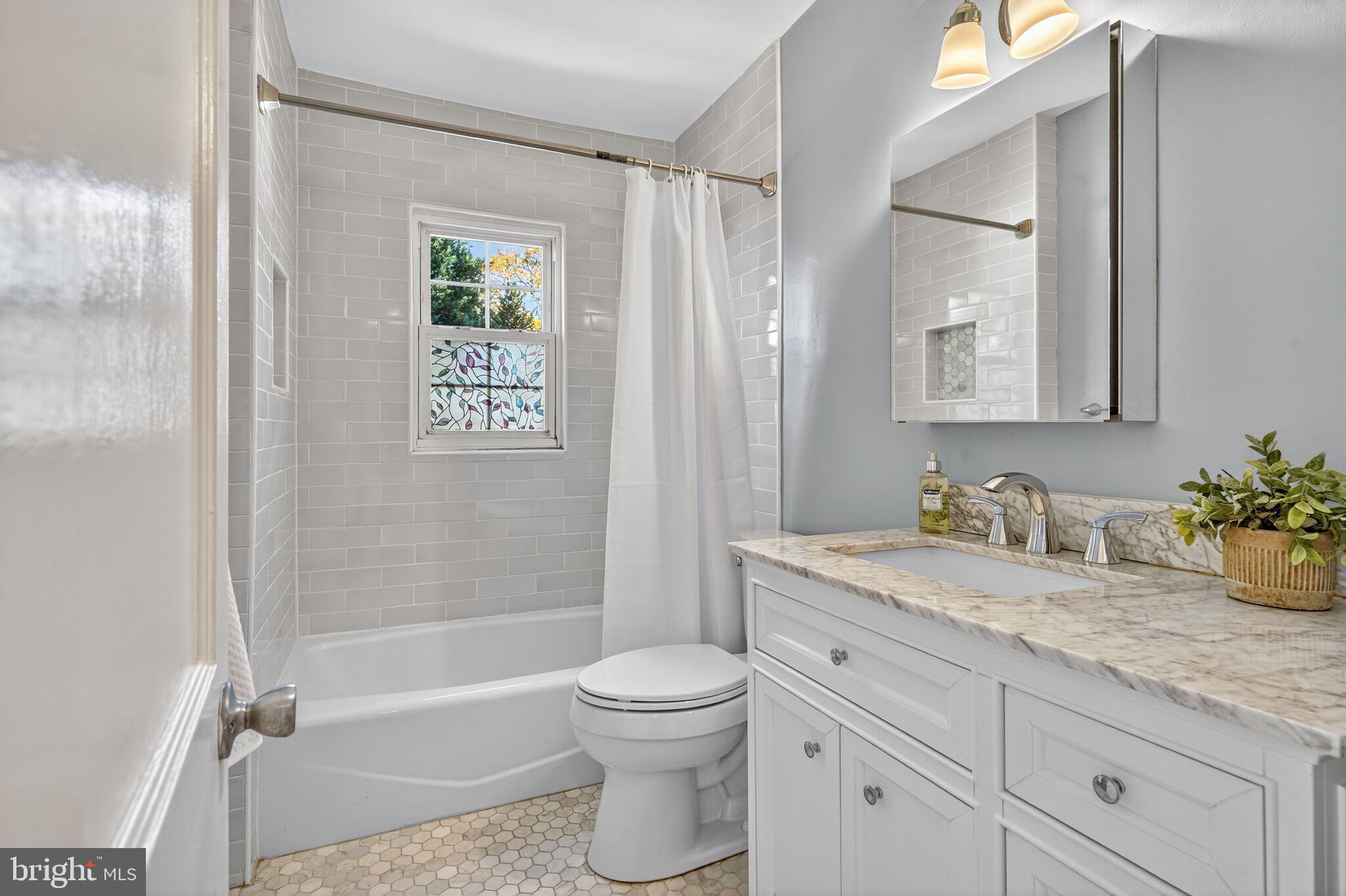 315 Ladson Road Silver Spring, MD 20901 - Photo 17 of 26 a bathroom with a granite countertop toilet a sink and a bathtub