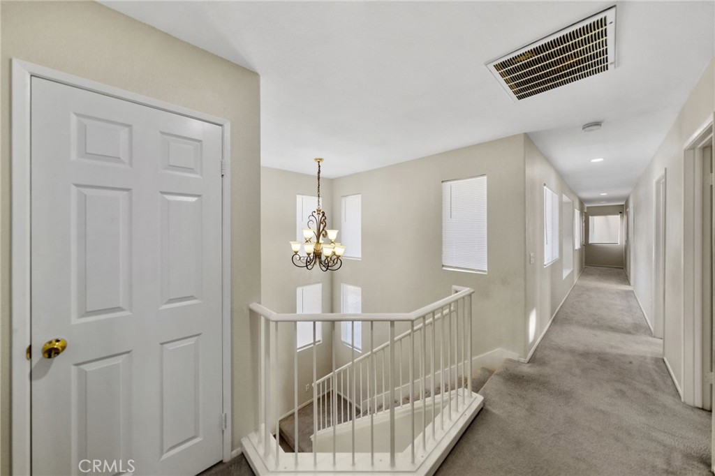 1494 Rabbit Peak Way Hemet, CA 92545 - Photo 22 of 45 a view of a hallway to a livingroom with wooden floor and stairs