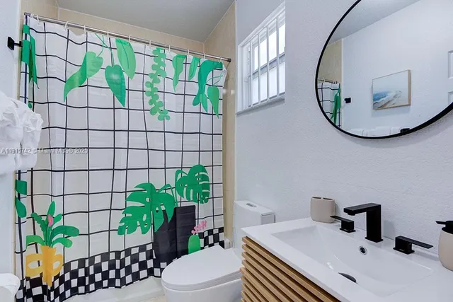 a bathroom with a sink mirror and toilet