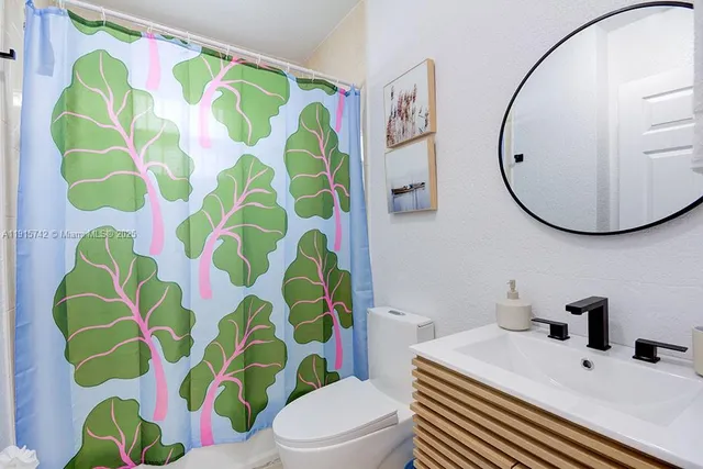 a bathroom with a sink toilet and mirror