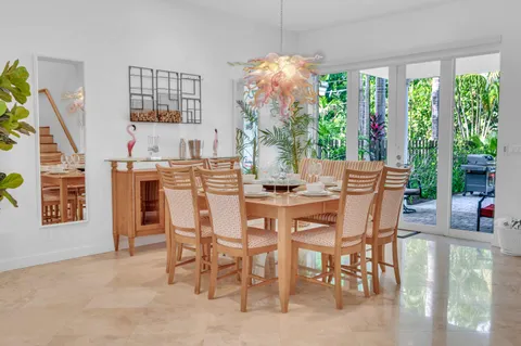 a dining room with furniture large windows and a chandelier