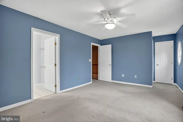 a view of an empty room with a ceiling fan