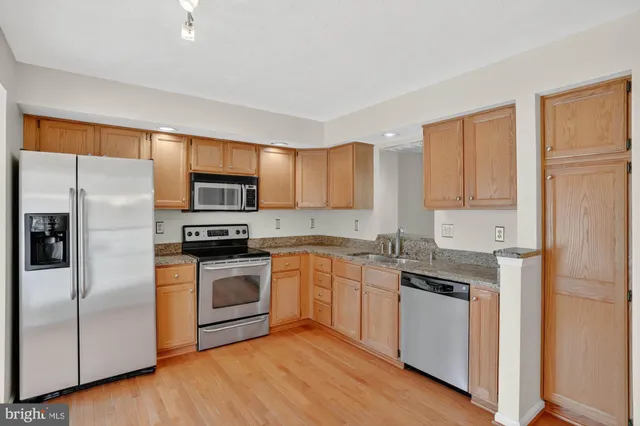 a kitchen with stainless steel appliances granite countertop a stove a sink and a refrigerator