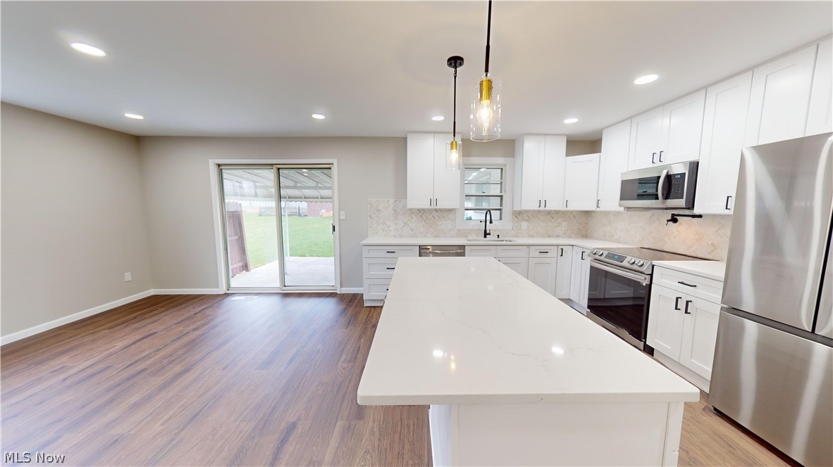 1224 Cordova Road Mayfield Heights, OH 44124 - Photo 11 of 29 Kitchen featuring appliances with stainless steel finishes, pendant lighting, and white cabinets