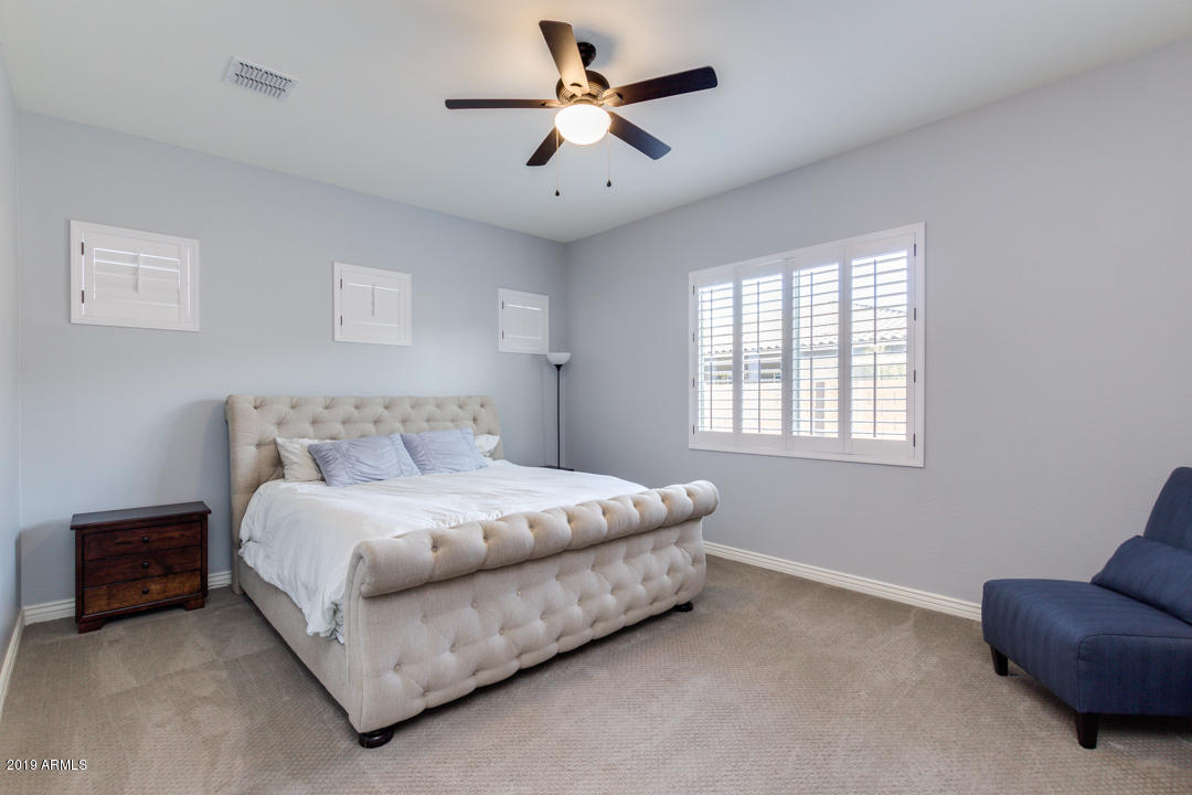 2665 East Stacey Road Gilbert, AZ 85298 - Photo 25 of 56 a spacious bedroom with a bed and a chandelier