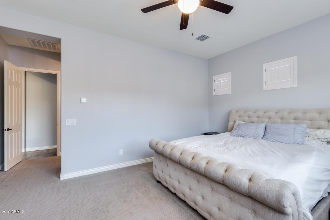 2665 East Stacey Road Gilbert, AZ 85298 - Photo 26 of 56 a bedroom with a large bed and a chandelier fan