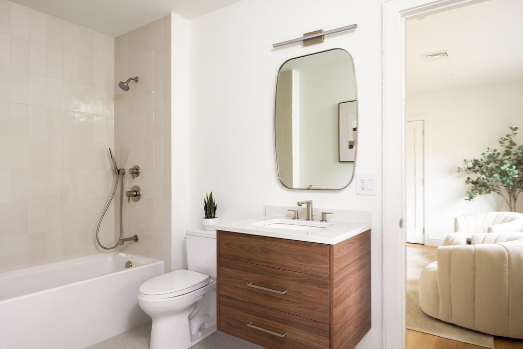 68 Mignon Road Newton, MA 02465 - Photo 20 of 33 a bathroom with a double vanity sink toilet mirror and bathtub