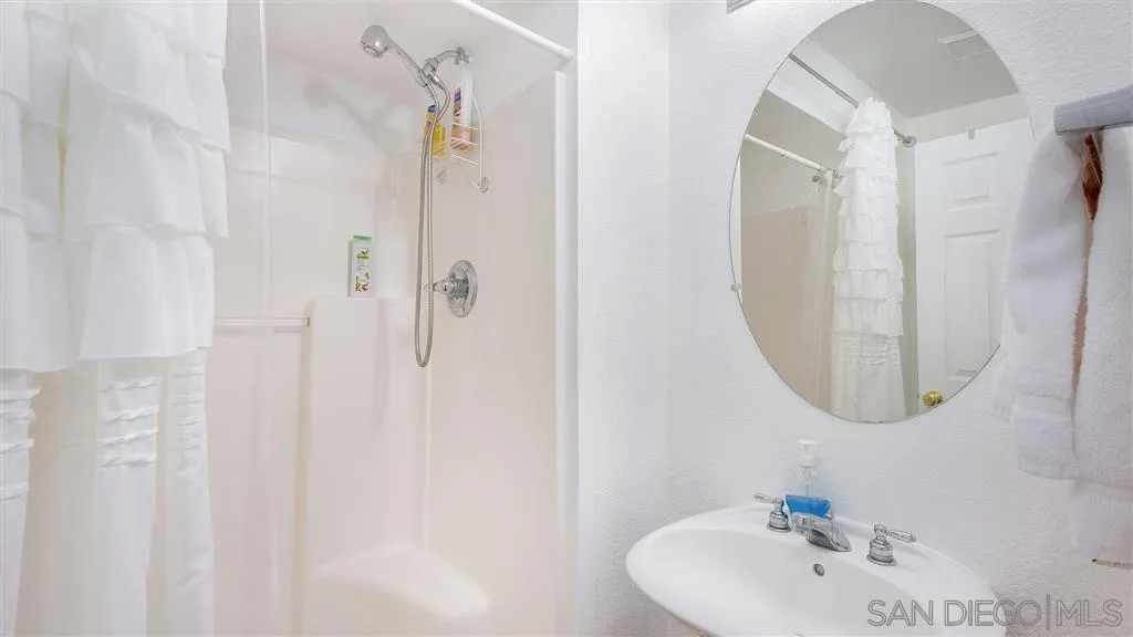 769 Avenida Codorniz San Marcos, CA 92069 - Photo 23 of 25 a bathroom with a sink a mirror and shower