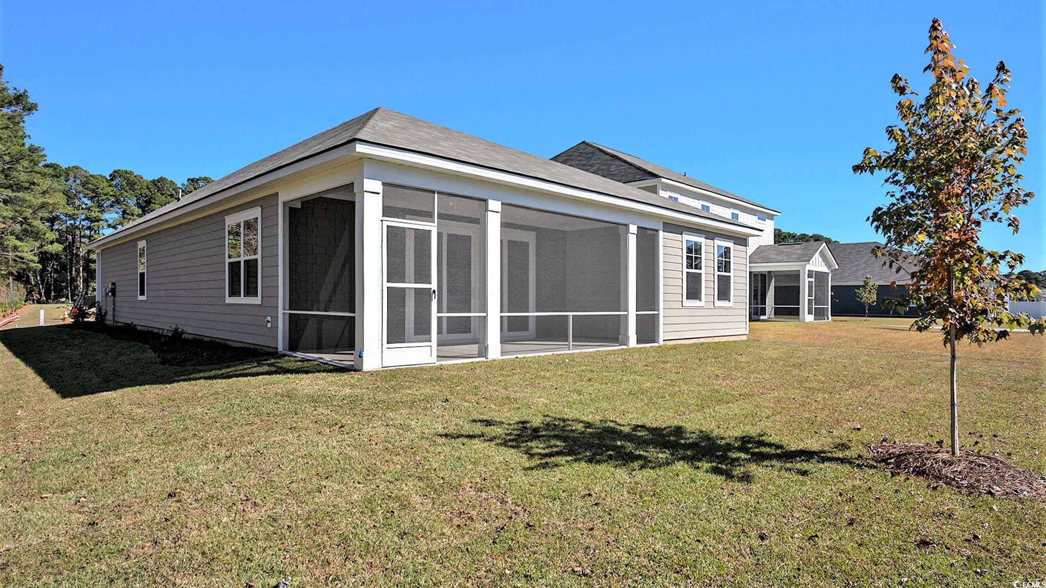 502 Haven View Way Murrells Inlet, SC 29576 - Photo 3 of 34 Rear view of house featuring a lawn and a sunroom