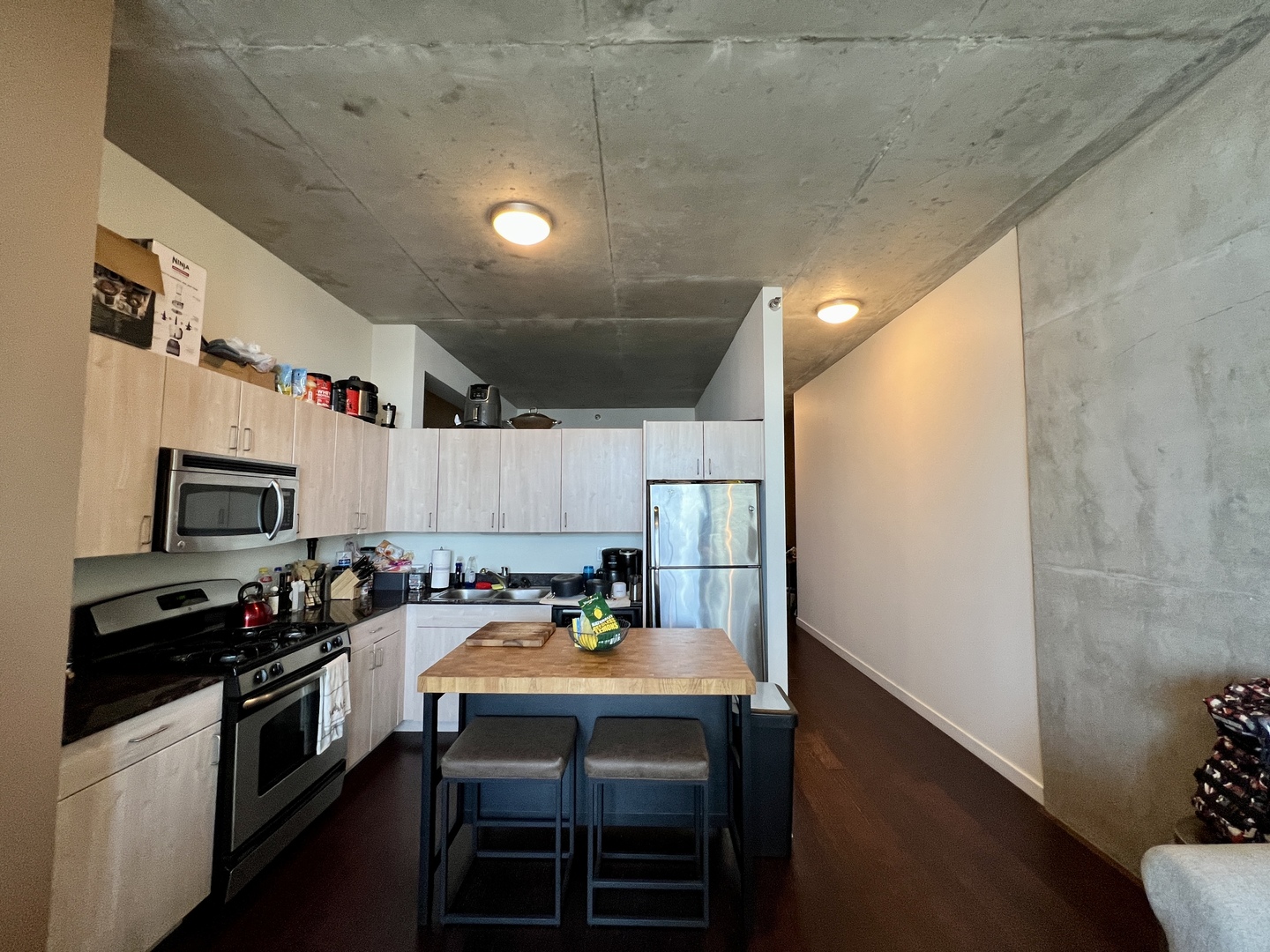 235 West Van Buren Street, Unit 3310 Chicago, IL 60607 - Photo 4 of 18 a kitchen with kitchen island a white counter top space cabinets and stainless steel appliances