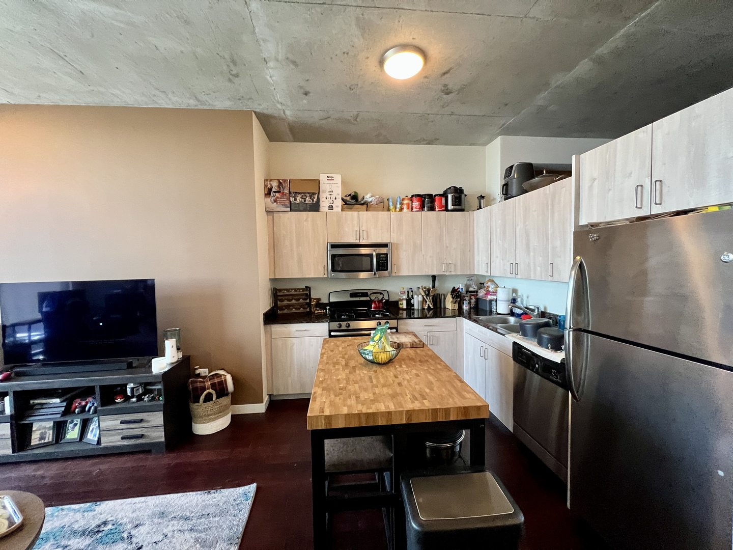 235 West Van Buren Street, Unit 3310 Chicago, IL 60607 - Photo 5 of 18 a kitchen with stainless steel appliances granite countertop a refrigerator stove top oven a sink and chairs