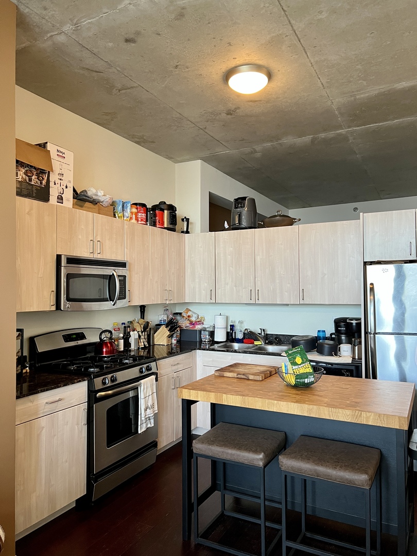 235 West Van Buren Street, Unit 3310 Chicago, IL 60607 - Photo 6 of 18 a kitchen with stainless steel appliances a stove a sink a microwave a refrigerator and cabinets