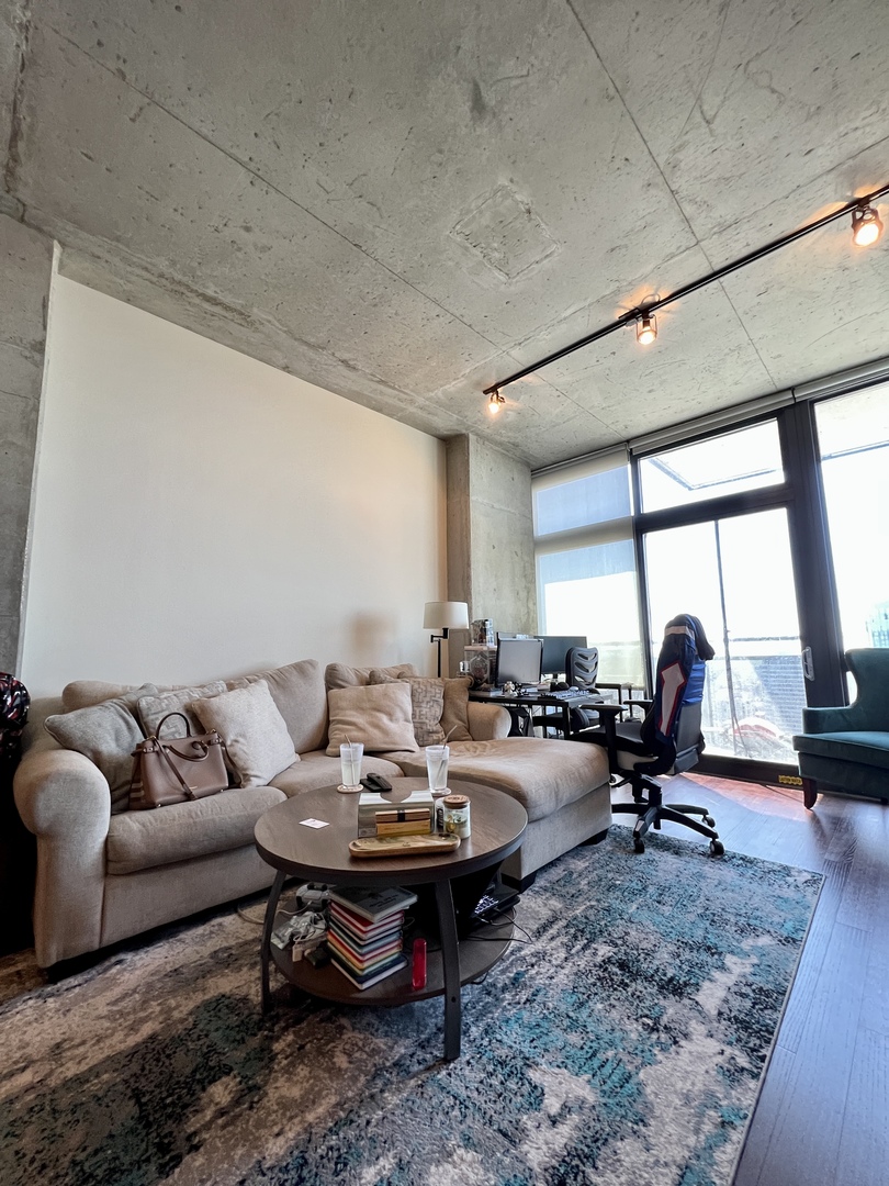 235 West Van Buren Street, Unit 3310 Chicago, IL 60607 - Photo 10 of 18 a living room with furniture and floor to ceiling window