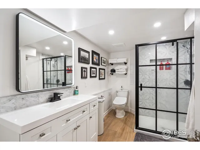 a bathroom with a toilet sink double vanity and mirror