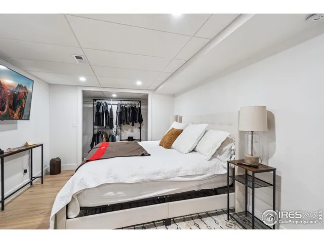 a bed room with a bed window and a flat screen tv