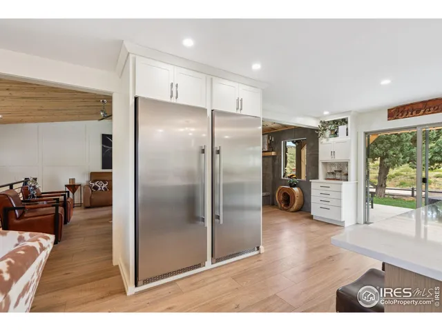 a kitchen with stainless steel appliances refrigerator and wooden floor