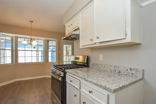a kitchen with stainless steel appliances granite countertop a sink stove and cabinets