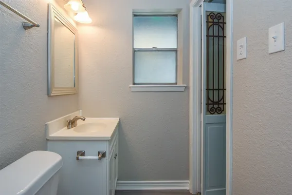 a bathroom with a sink and mirror with toilet