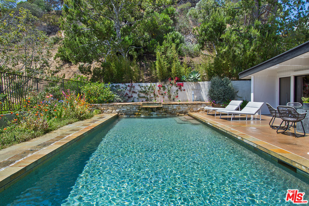 1071 Tellem Drive Pacific Palisades, CA 90272 - Photo 18 of 26 a swimming pool with outdoor seating and yard