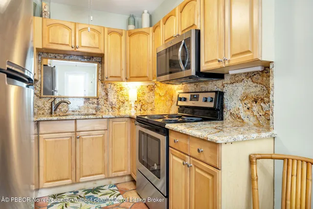 a kitchen with stainless steel appliances granite countertop a stove a sink and a microwave