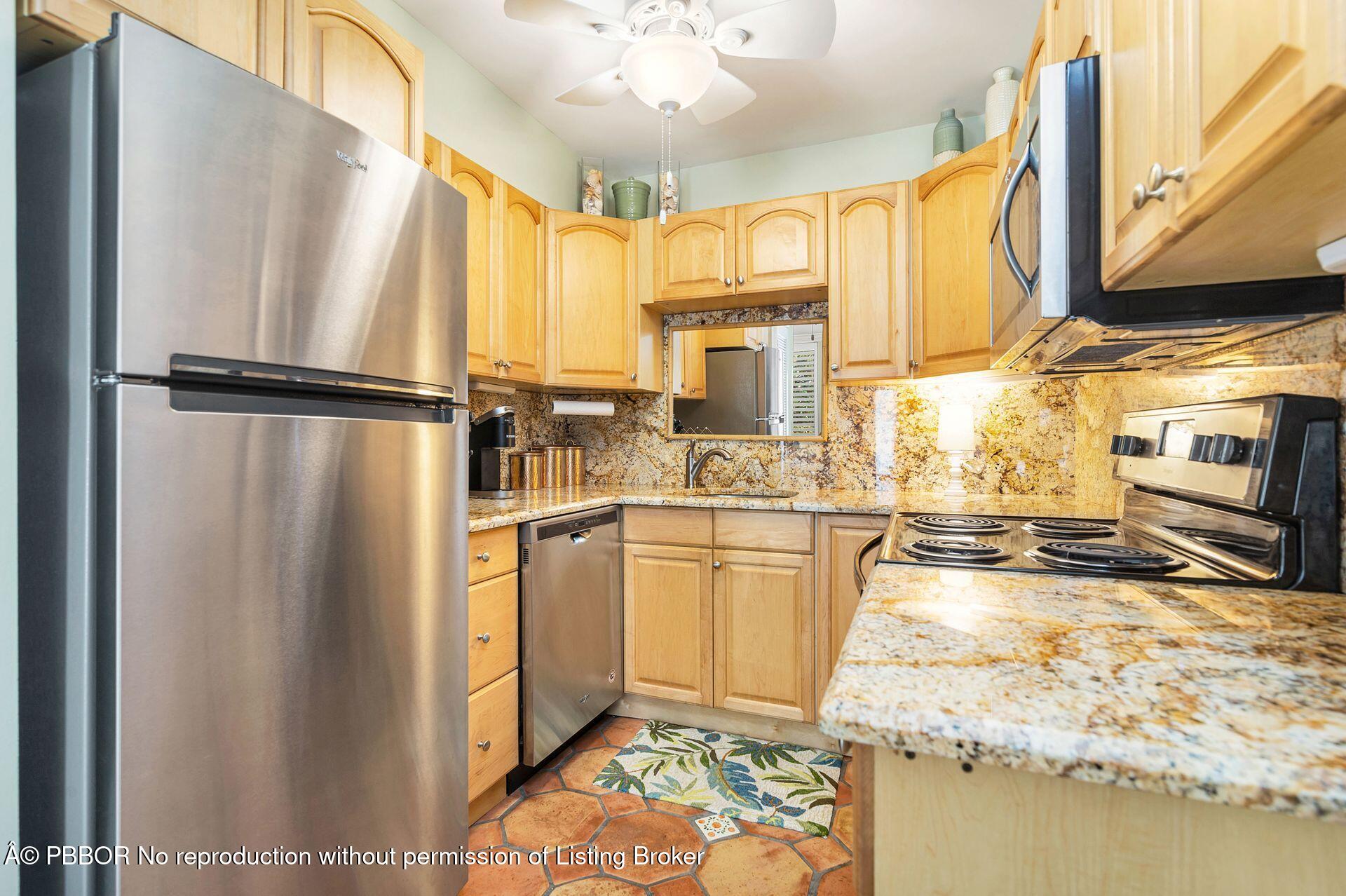 401 Peruvian Avenue, Unit 1050 Palm Beach, FL 33480 - Photo 6 of 17 a kitchen with stainless steel appliances granite countertop a refrigerator a oven and white cabinets with wooden floors