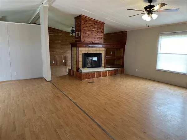 a view of an empty room with a fireplace and a window