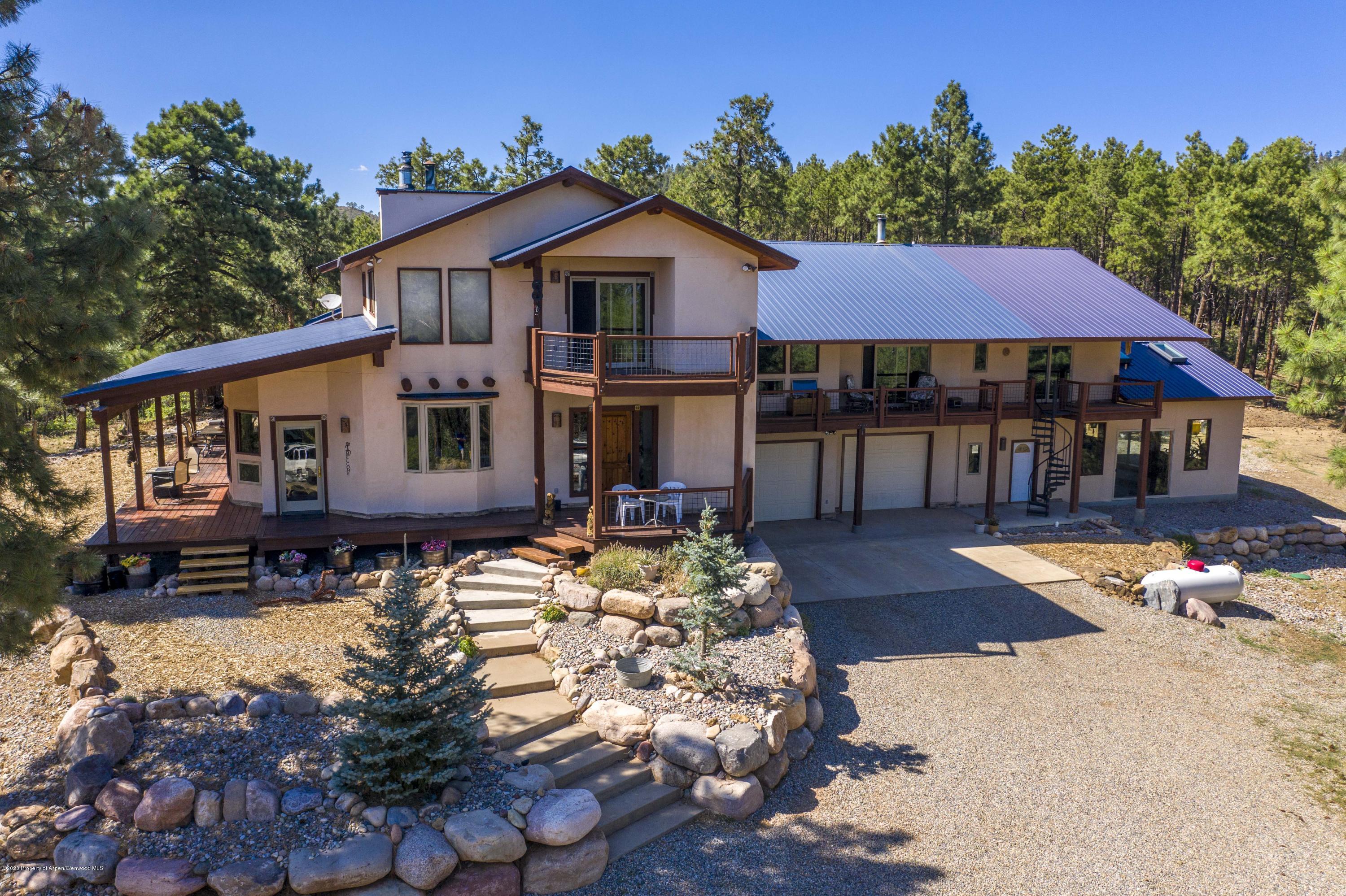 1350 Rincon Ridge Road Durango, CO 81301 - Photo 46 of 48 a aerial view of a house with table and chairs under an umbrella