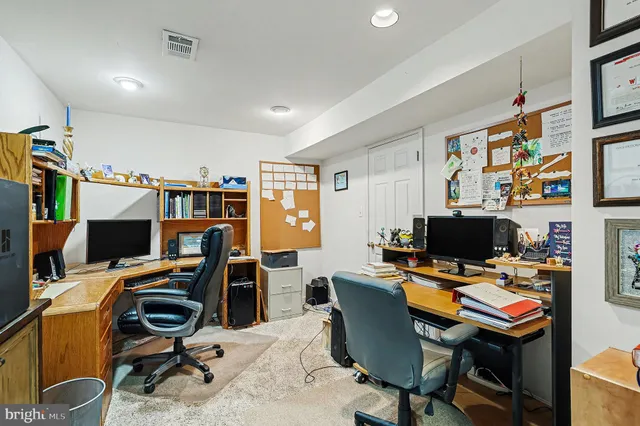 a view of a workspace with furniture and a window