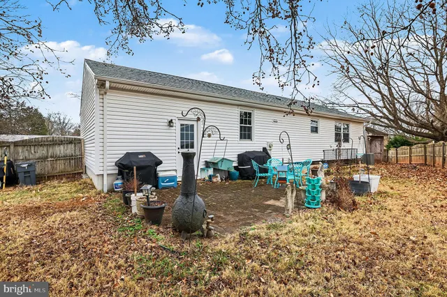 a view of a chair and table in backyard of the house