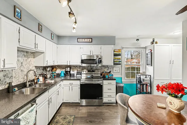 a kitchen with stainless steel appliances kitchen island granite countertop a sink dishwasher stove top oven and cabinets