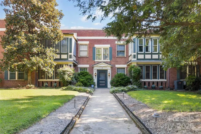 a front view of a residential apartment building with a yard