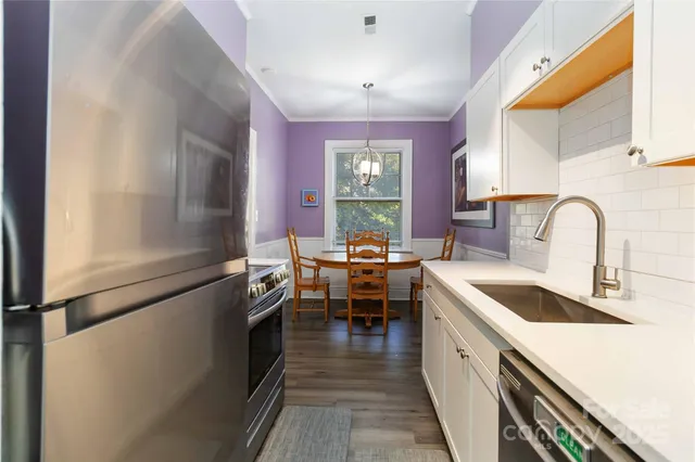 a kitchen with kitchen island granite countertop a sink stove and cabinets