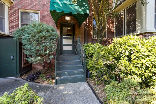 a view of a house with a yard and potted plants