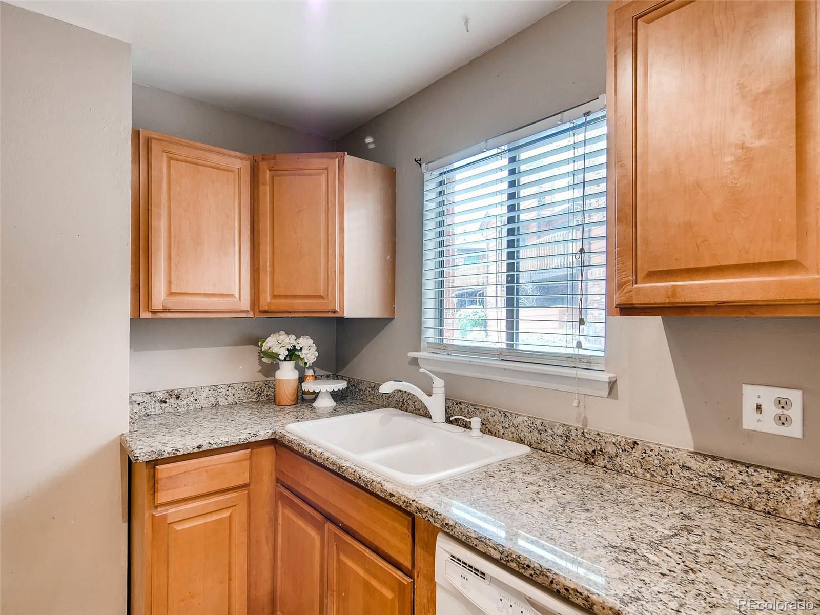 2263 South Buckley Road, Unit 101 Aurora, CO 80013 - Photo 6 of 11 a kitchen with granite countertop sink cabinets and window